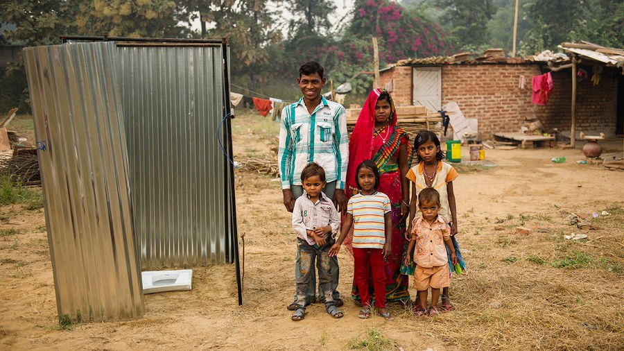 Family in Asia next to a sanitation project from Gospel for Asia