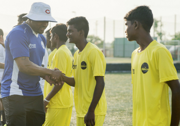 Former NFL star Rashied Davis with participants in a soccer event in India who received a copy of Biblica’s Game of Life book, featuring Scripture and testimonies of leading Indian soccer players.