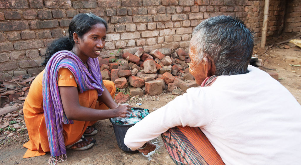 Gospel for Asia-supported worker Sakshi ministers to a leprosy patient.