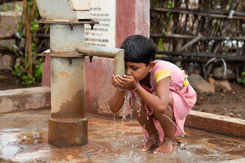 Little girl drinking clean water from Jesus Well