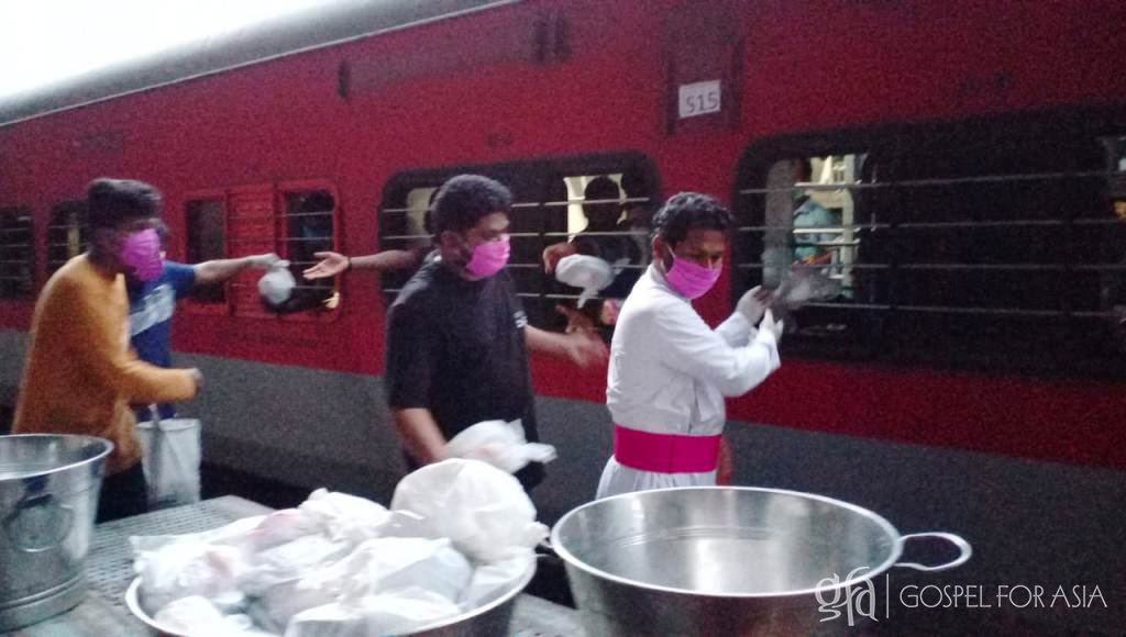 Gospel for Asia founded by Dr. K.P. Yohannan: Church staff hand out food to migrant workers traveling by train.