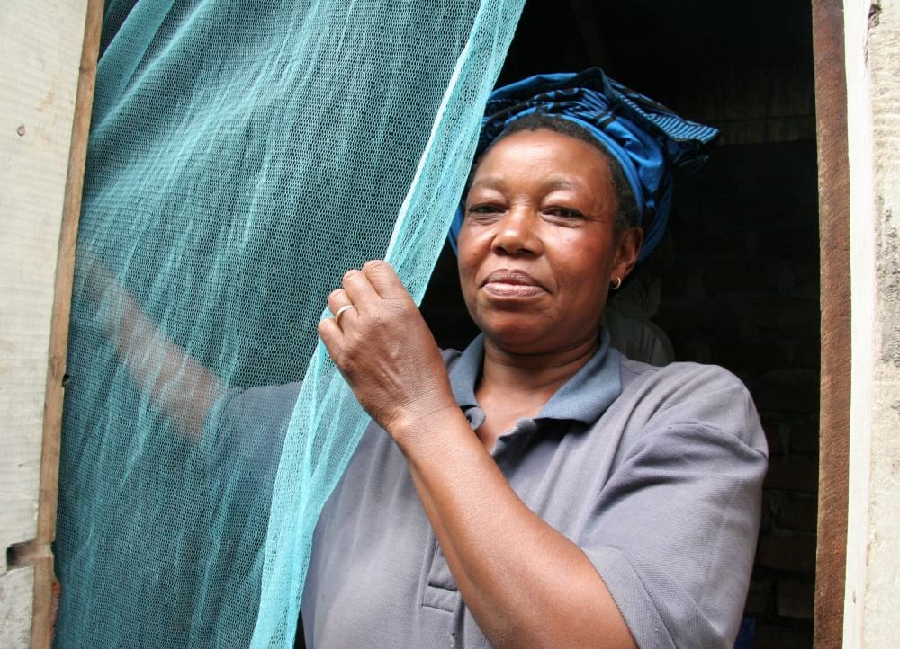 A woman puts up a mosquito bednet.