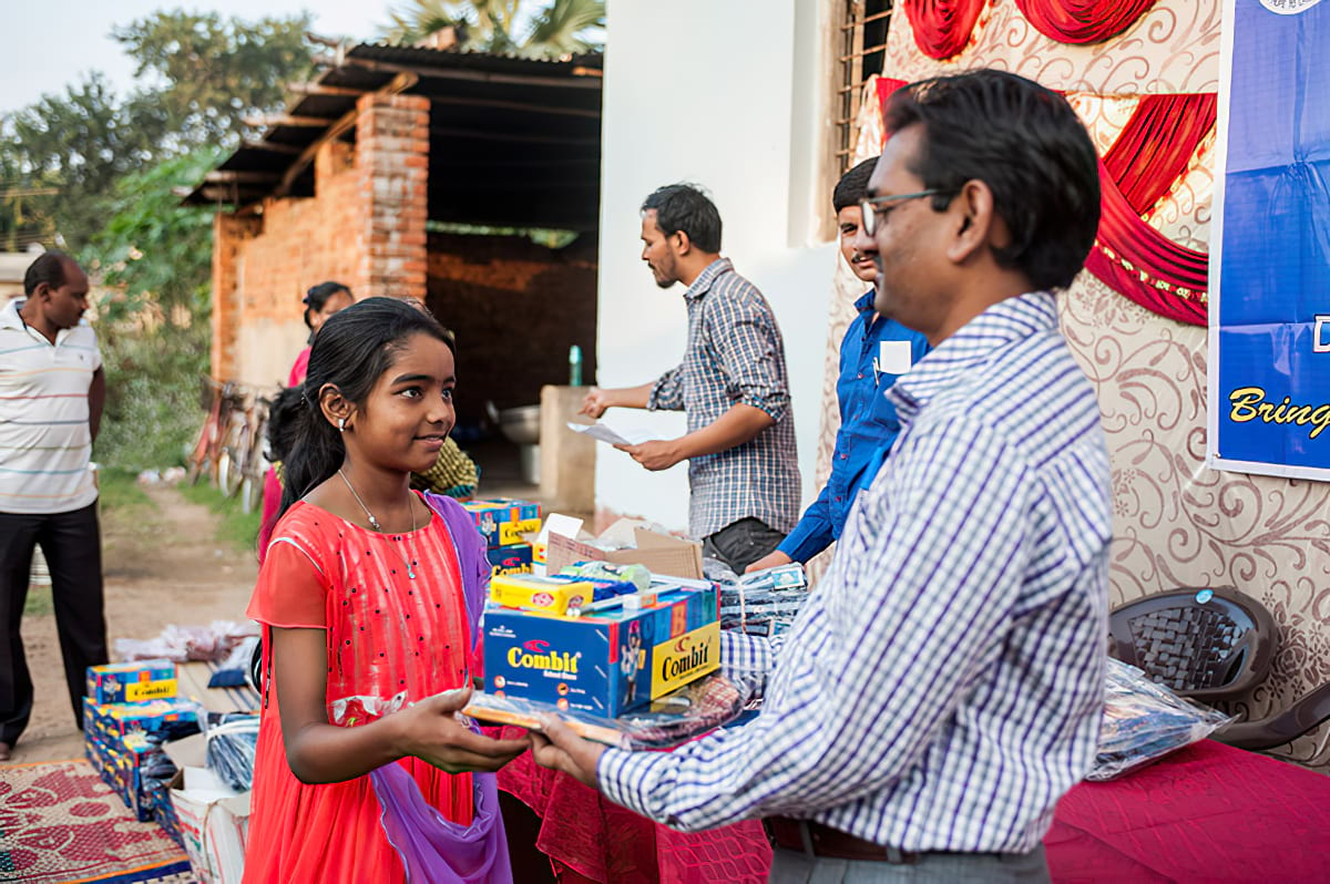 Girl receiving school supplies from Bridge of Hope center
