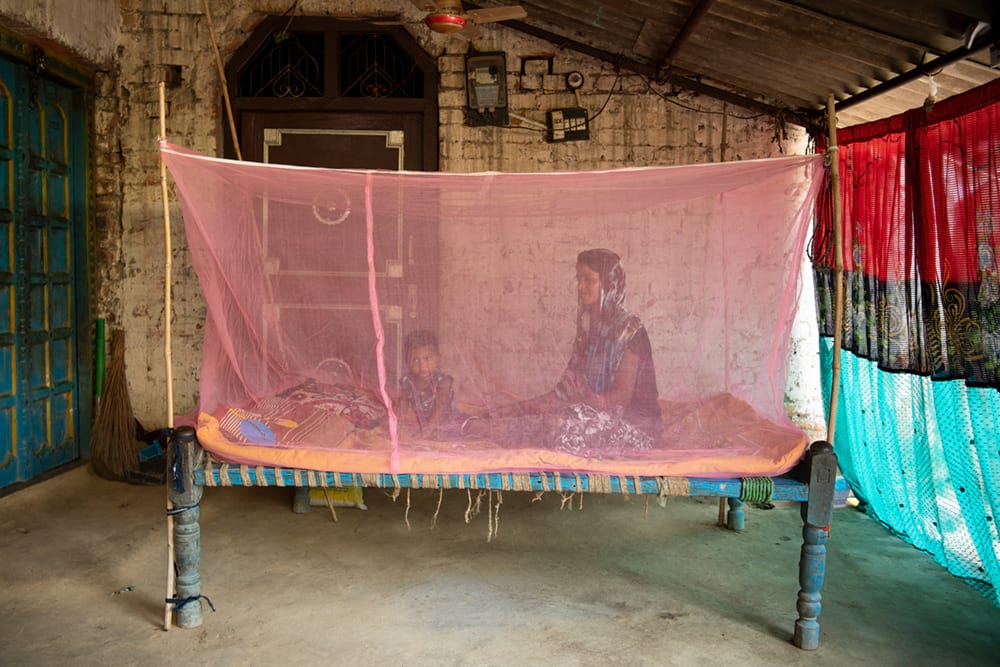 Mother and child resting inside their mosquito net