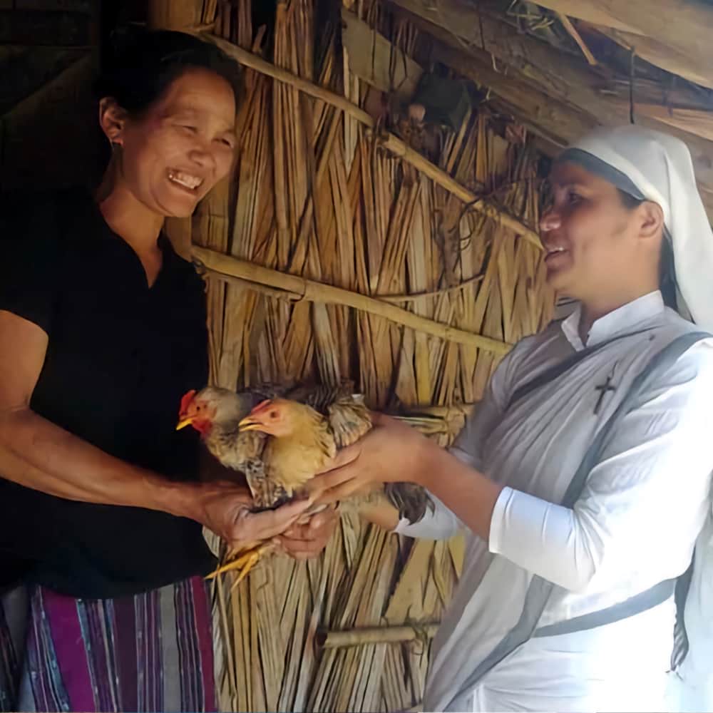 Neha receives a pair of chickens from GFA World Sisters of Compassion
