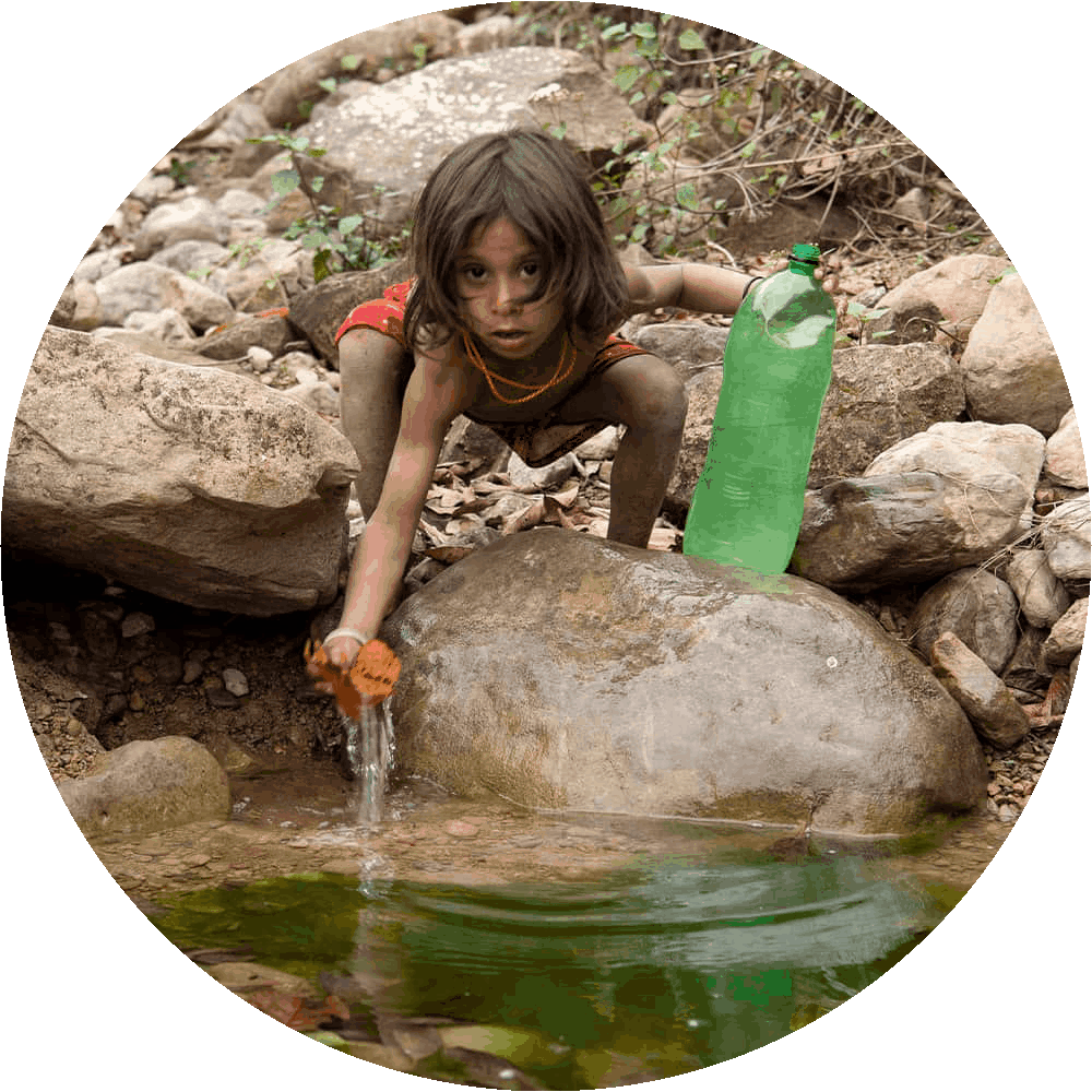 Boy from Nepal collects dirty water from a puddle for drinking